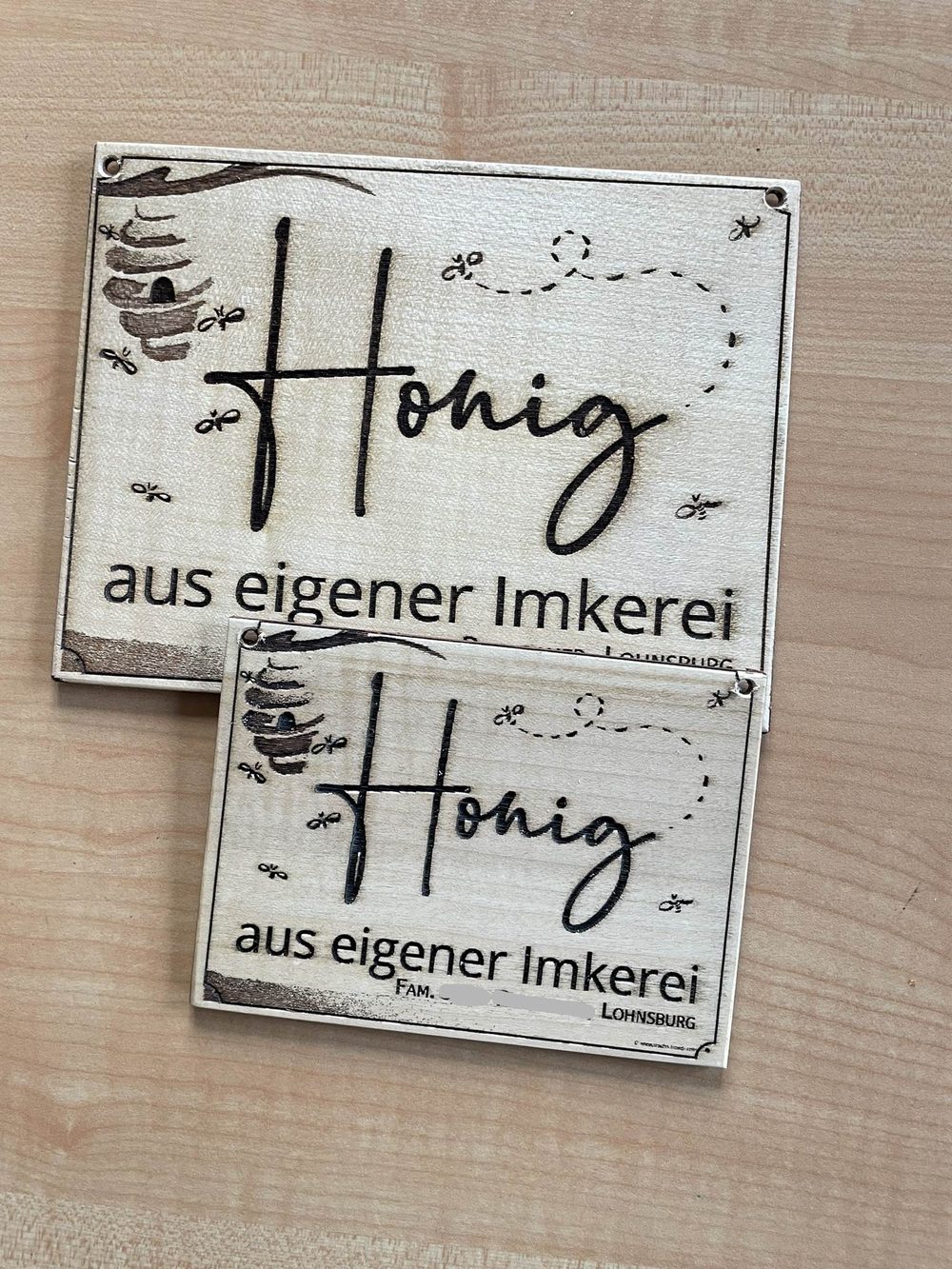 Zwei gravierte Holzschilder mit dem Schriftzug „Honig aus eigener Imkerei“, Bienenstock und Bienen, gefertigt in Lohnsburg